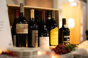 Wine bottles lined up in front of a wooden wine crate.